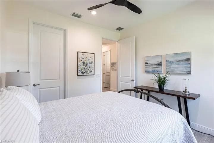 Bedroom with light hardwood / wood-style floors, a closet, and ceiling fan