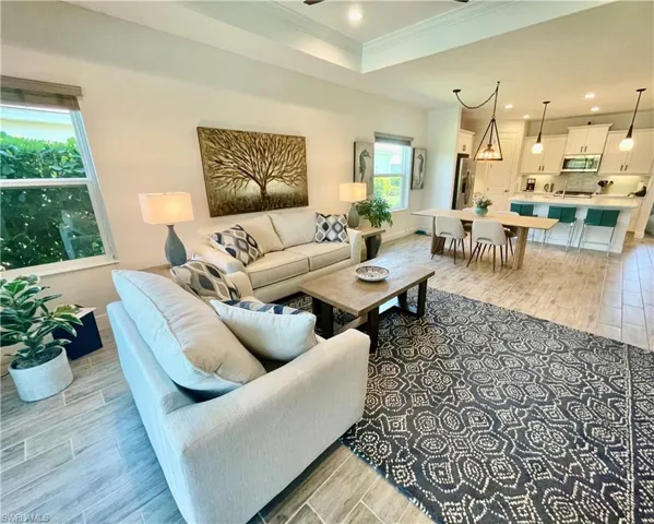Living area featuring recessed lighting, ceiling fan, crown molding, and ceramic wood finish floors