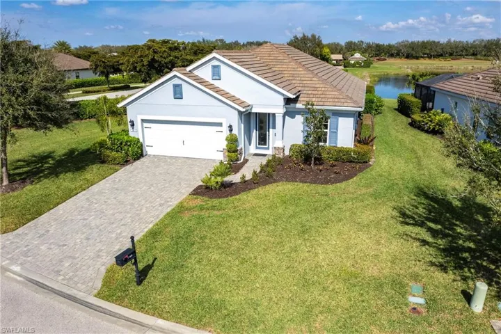 Single story home featuring a garage, a front yard, and a water view