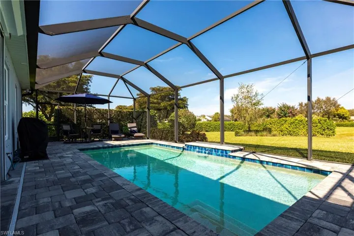 View of pool featuring area for grilling, a yard, a lanai, and a patio area