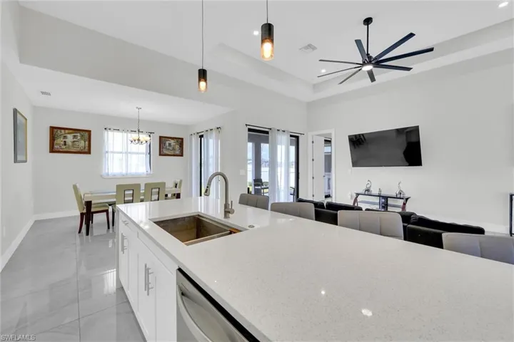 Kitchen featuring a sink, open floor plan, stainless steel dishwasher, and visible vents
