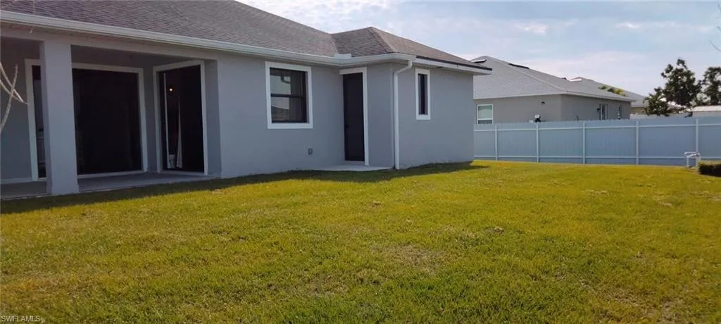 Back of property featuring a lawn