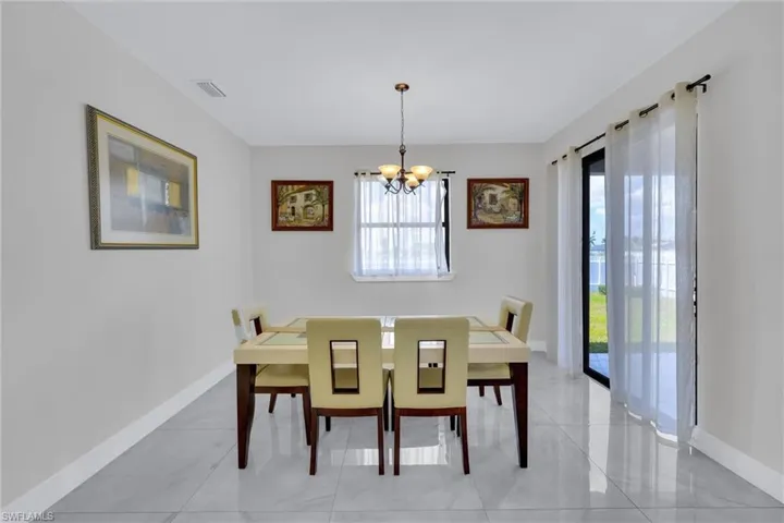 Dining area with a wealth of natural light, a notable chandelier, baseboards, and visible vents