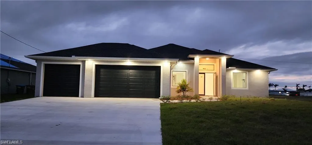 View of front of home with a garage and a front yard