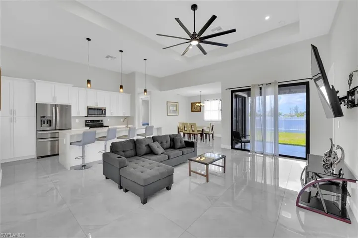 Living area featuring a tray ceiling, ceiling fan, and a towering ceiling