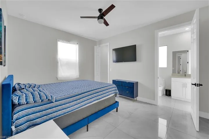 Bedroom with baseboards, a ceiling fan, and ensuite bath