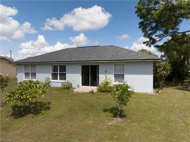 Back of house with a lawn
