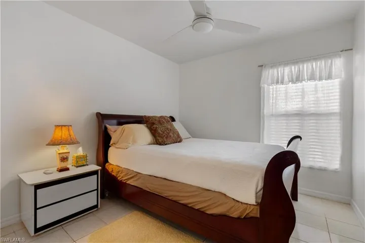 Bedroom with ceiling fan and light tile patterned floors