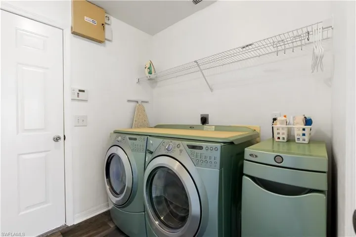 Laundry area with dark wood-type flooring and washer and dryer