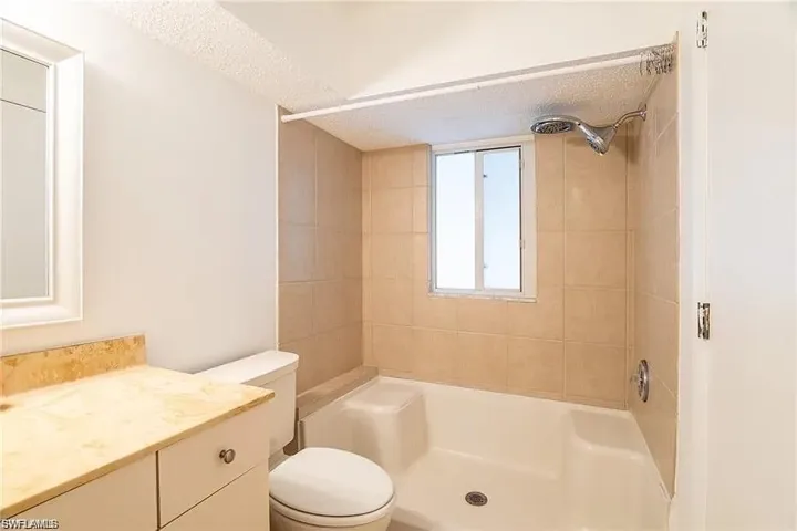 Full bath featuring a shower, vanity, and a textured ceiling
