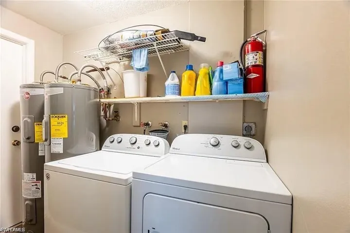 Washroom featuring washing machine and clothes dryer and water heater