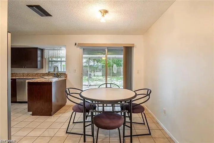 Dining area with a textured ceiling and light tile patterned floors
