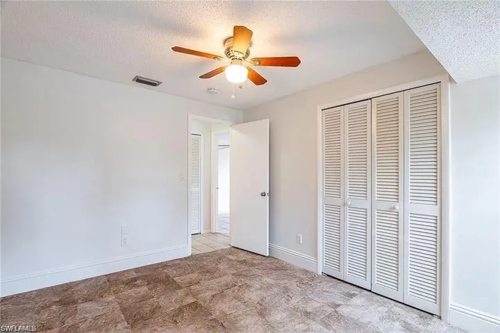 Unfurnished bedroom featuring a textured ceiling, a closet, and ceiling fan