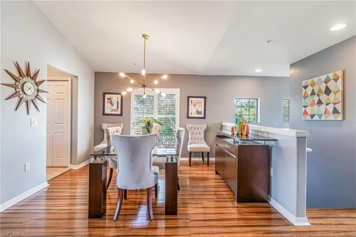 Dining area with a chandelier, plenty of natural light, and light laminate wood style  floors