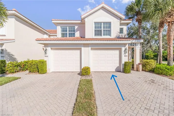 Mediterranean / spanish home featuring a pavered, extra wide driveway, stucco siding, an attached garage, and a tiled roof
