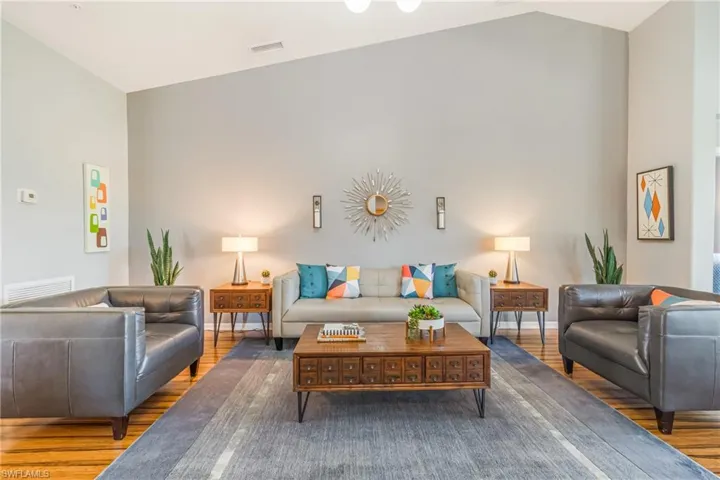 Living area with laminate wood style floors and high vaulted ceiling