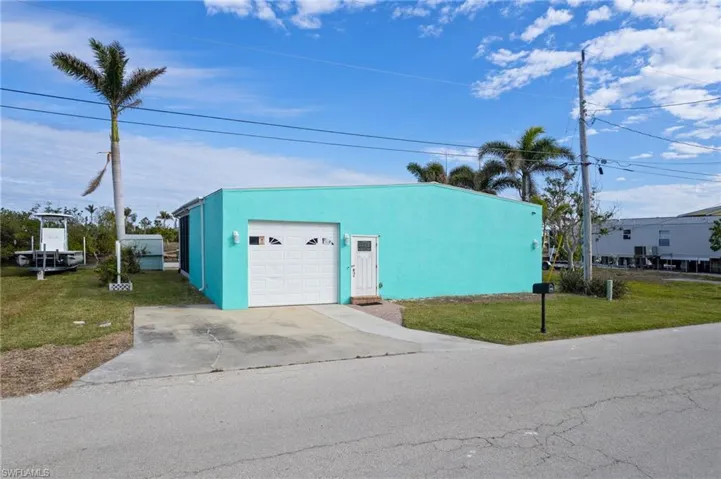 View of outbuilding featuring an outdoor structure, driveway, and an attached garage