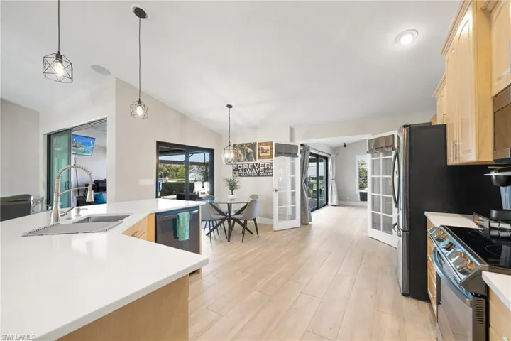 Kitchen featuring appliances with stainless steel finishes, french doors, a sink, and light brown cabinetry