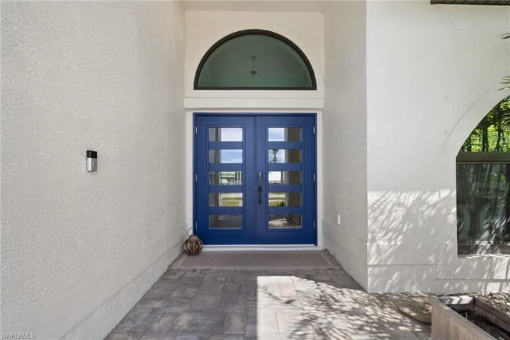 Property entrance with stucco siding and french doors