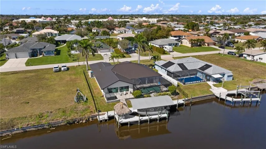 Birds eye view of property with a water view and a residential view