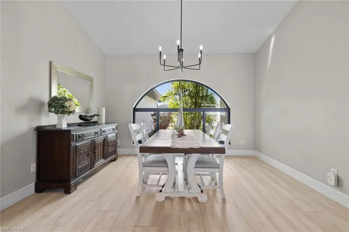 Dining space with light wood-style flooring, baseboards, and an inviting chandelier