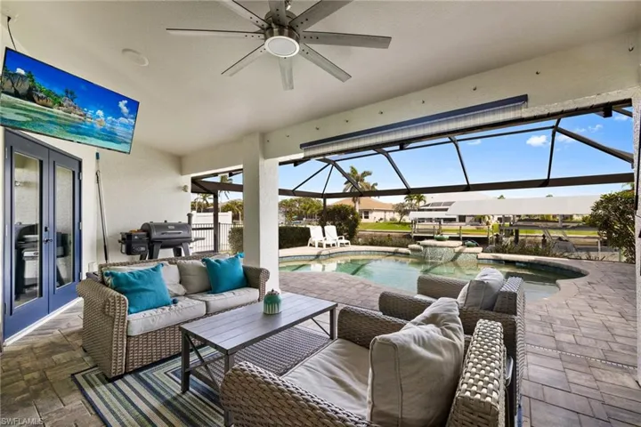 View of patio with glass enclosure, french doors, grilling area, and an outdoor living space