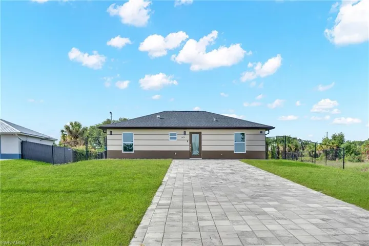Single-story residence featuring a neutral-toned exterior with dark brown accents, a dark shingle roof, and a paver driveway