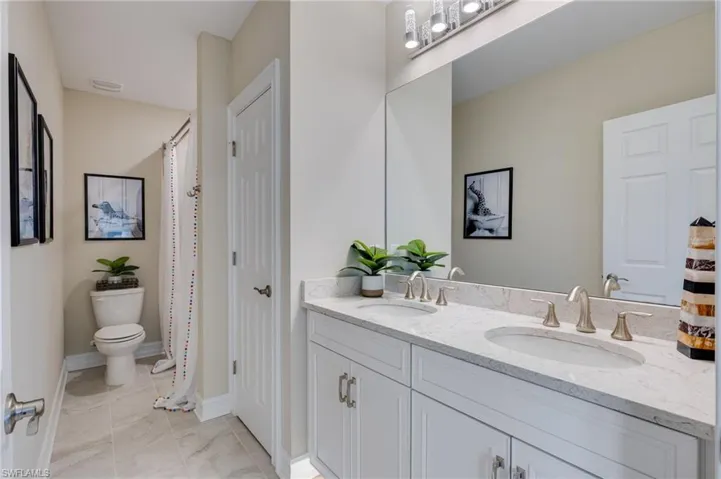 Full bath featuring double vanity, a closet, and curtained shower