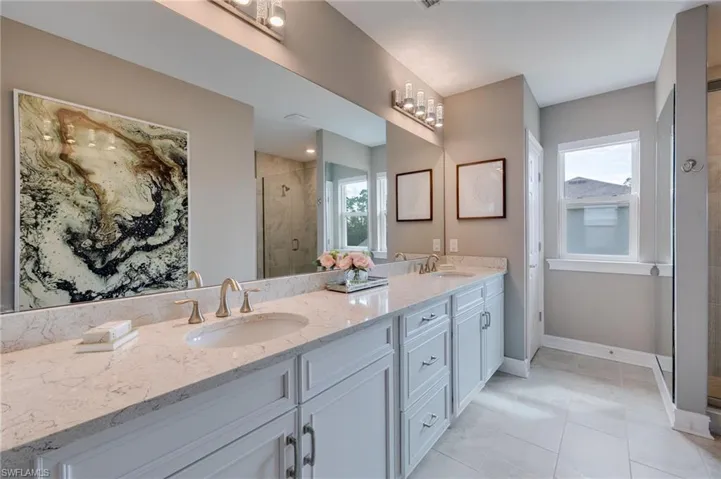 MASTER bathroom featuring a shower stall, double vanity, and light tile patterned floors