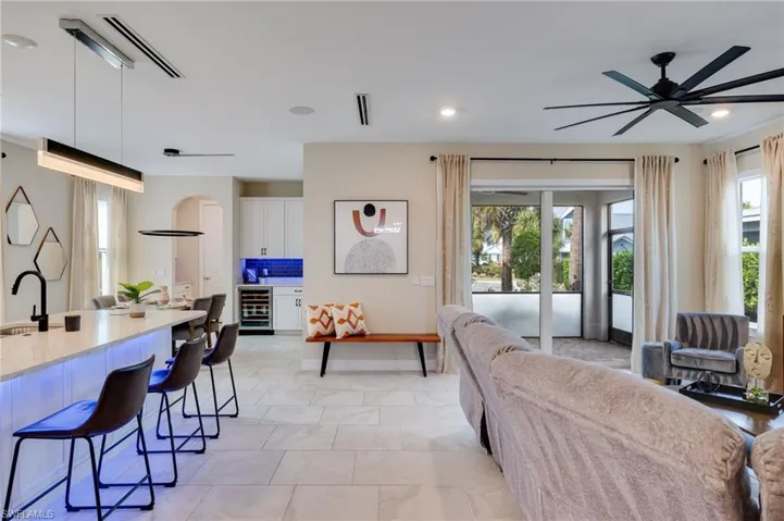 Living area, ceiling fan, healthy amount of natural light, beverage cooler, and recessed lighting