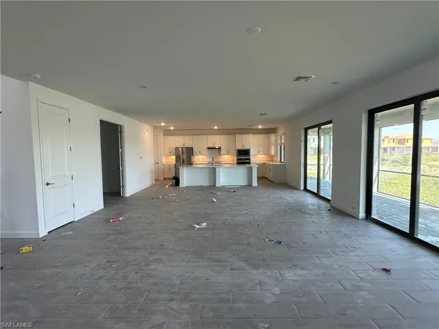 Unfurnished living room with tile floors and sink