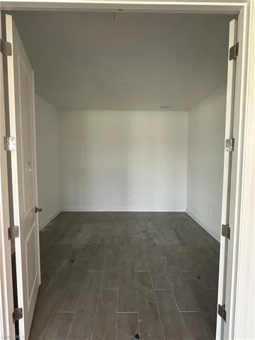 Empty room with dark wood-type flooring