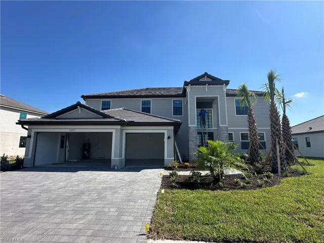 View of front of house with a garage and a front lawn