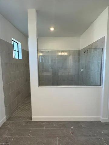 Bathroom with a tile shower and tile flooring