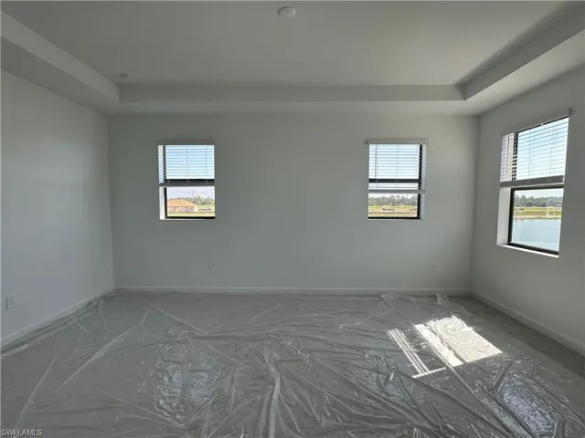Spare room featuring a raised ceiling and a water view