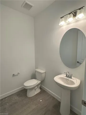 Bathroom with hardwood / wood-style flooring and toilet