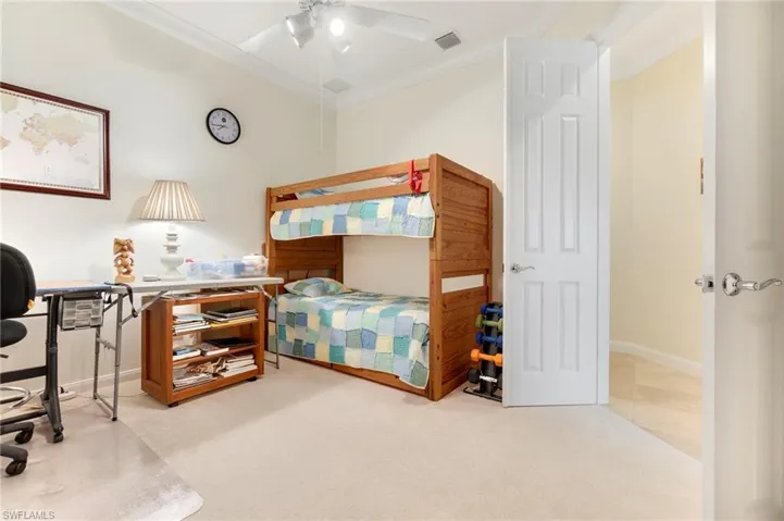 Carpeted bedroom featuring ceiling fan and ornamental molding