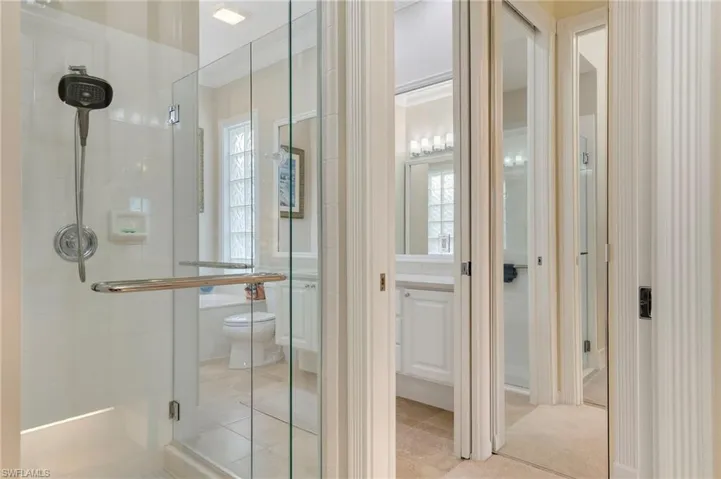 Bathroom with crown molding, an enclosed shower, and toilet