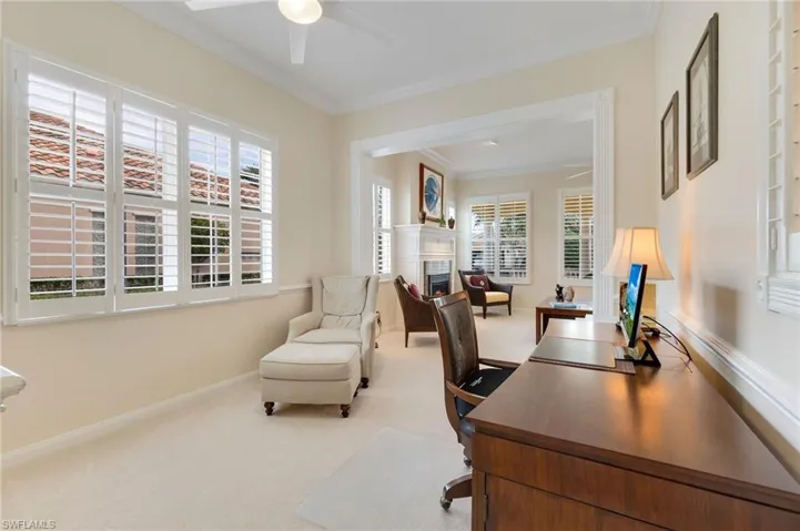 Office area featuring carpet floors, crown molding, ceiling fan, and a healthy amount of sunlight