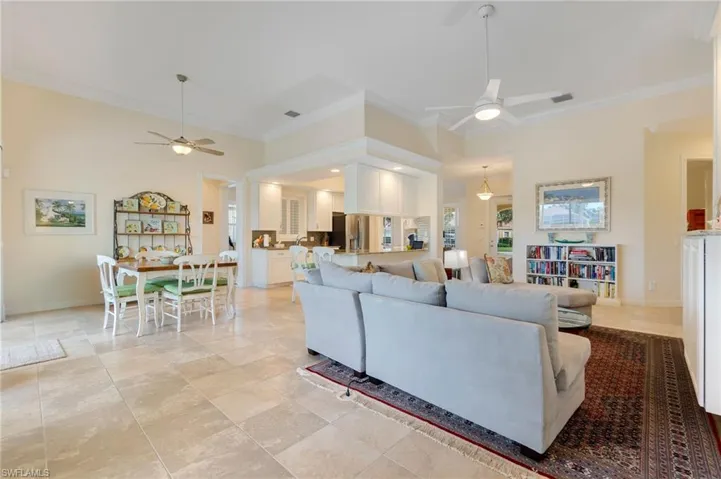 Living room with ceiling fan and ornamental molding