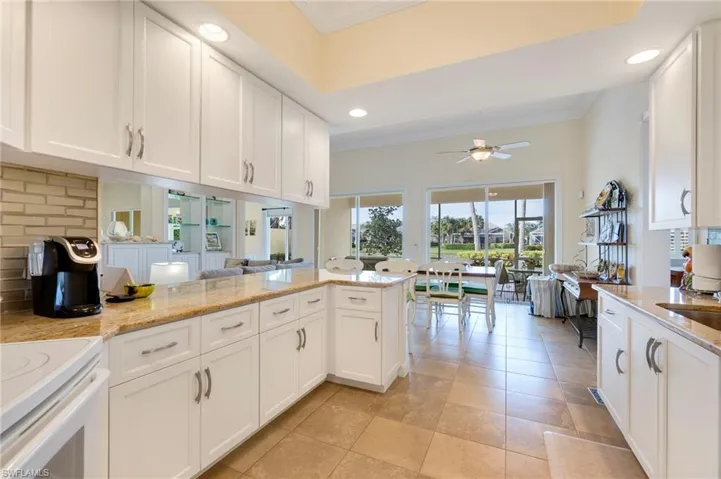 Kitchen featuring kitchen peninsula, white cabinetry, and ceiling fan
