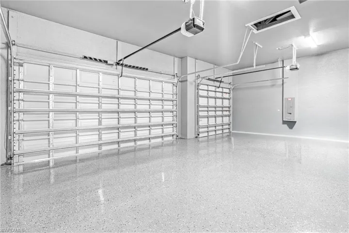 Garage featuring a garage door opener and electric panel