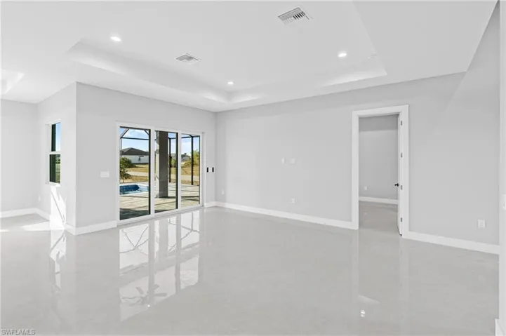 Unfurnished room featuring a raised ceiling and recessed lighting