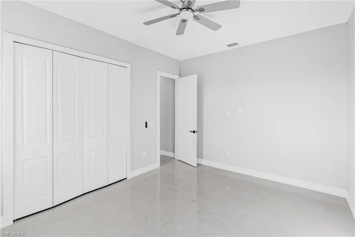 Unfurnished bedroom featuring a ceiling fan and a closet