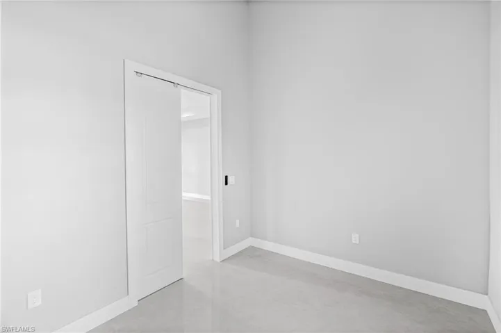 Spare room with baseboards and concrete flooring