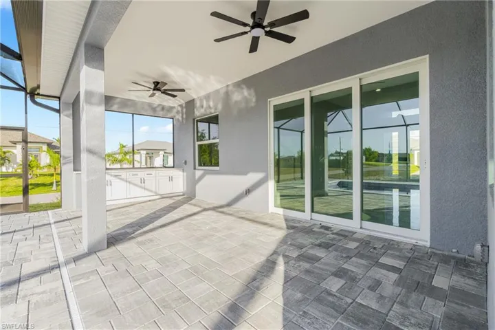 View of patio with a sunroom, a ceiling fan, and a lanai