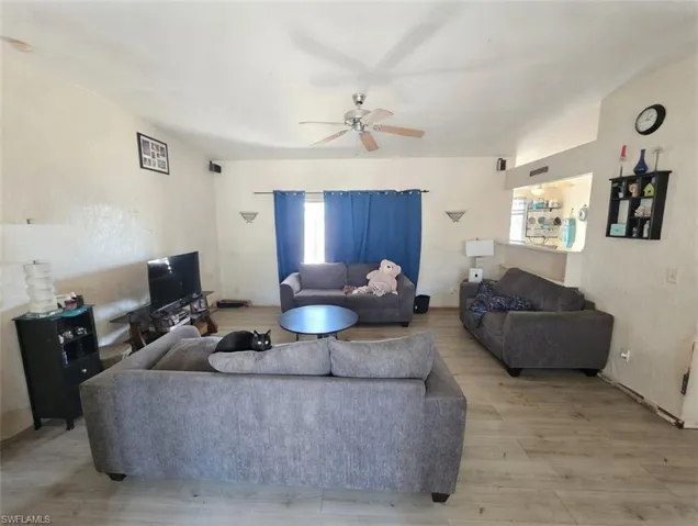 Living area with a ceiling fan and wood finished floors