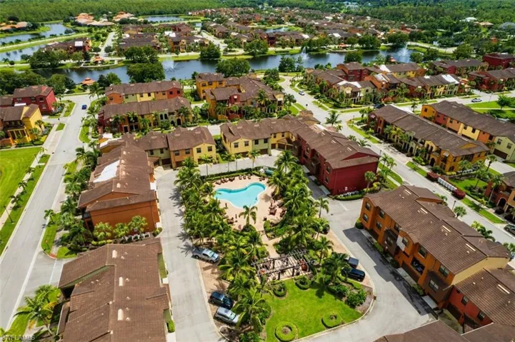 Aerial perspective of suburban area featuring a large body of water and a pool area