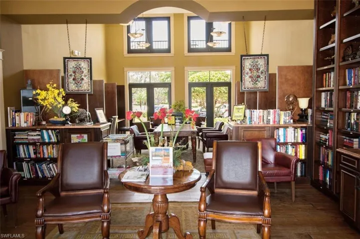 Sitting room with hardwood / wood-style floors, arched walkways, and a high ceiling