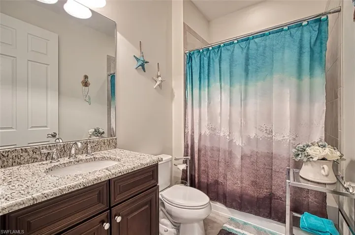 Bathroom with vanity, toilet, and shower / bath combo